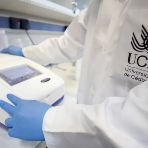 Investigador de la Universidad de Cádiz usando equipo de laboratorio, enfocado en sostenibilidad.
